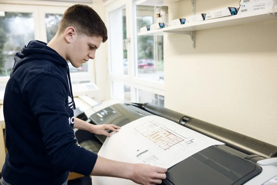 Mitarbeiter prüft Planausdruck