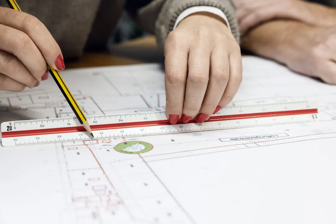 Person zeichnet auf Plan ein.